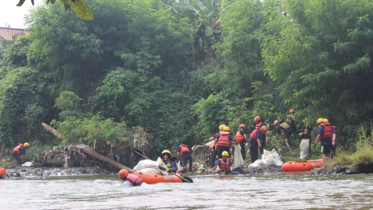 Jajaran karyawan dari PT Praisindo Teknologi saat melakukan aksi bersih-bersih Sungai Ciliwung. (Yudha Prananda / Jabar Ekspres)