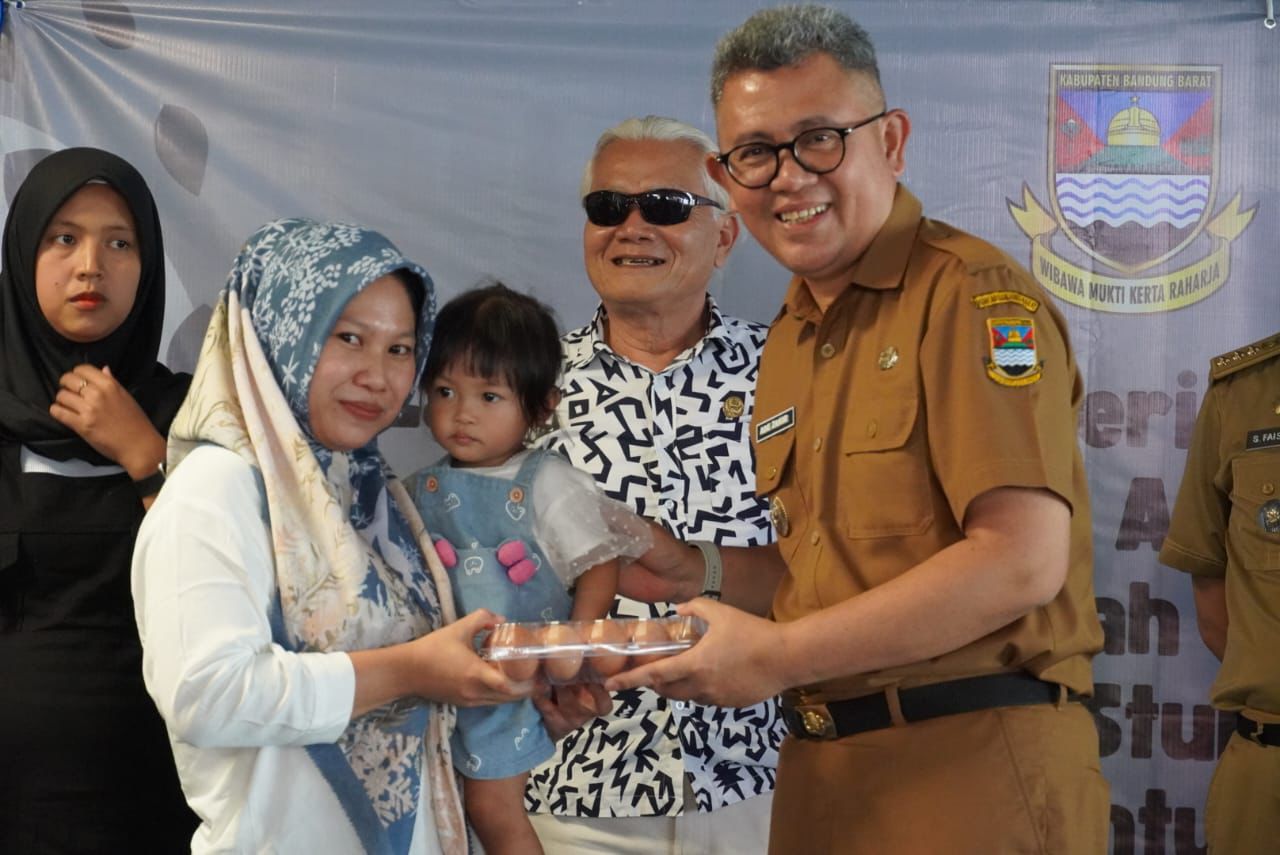 Pj Bupati Bandung Barat, Ade Zakir saat memberikan pangan lokal bergizi kepada ibu hamil (bumil) dan balita di wilayah Kecamatan Cipatat. Selasa (19/11). Dok Prokompim KBB