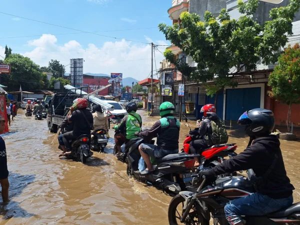 Masyarakat saat melintas Jalan Raya Dayeuhkolot yang tergenang banjir pada Kamis (21/11). Foto Agi