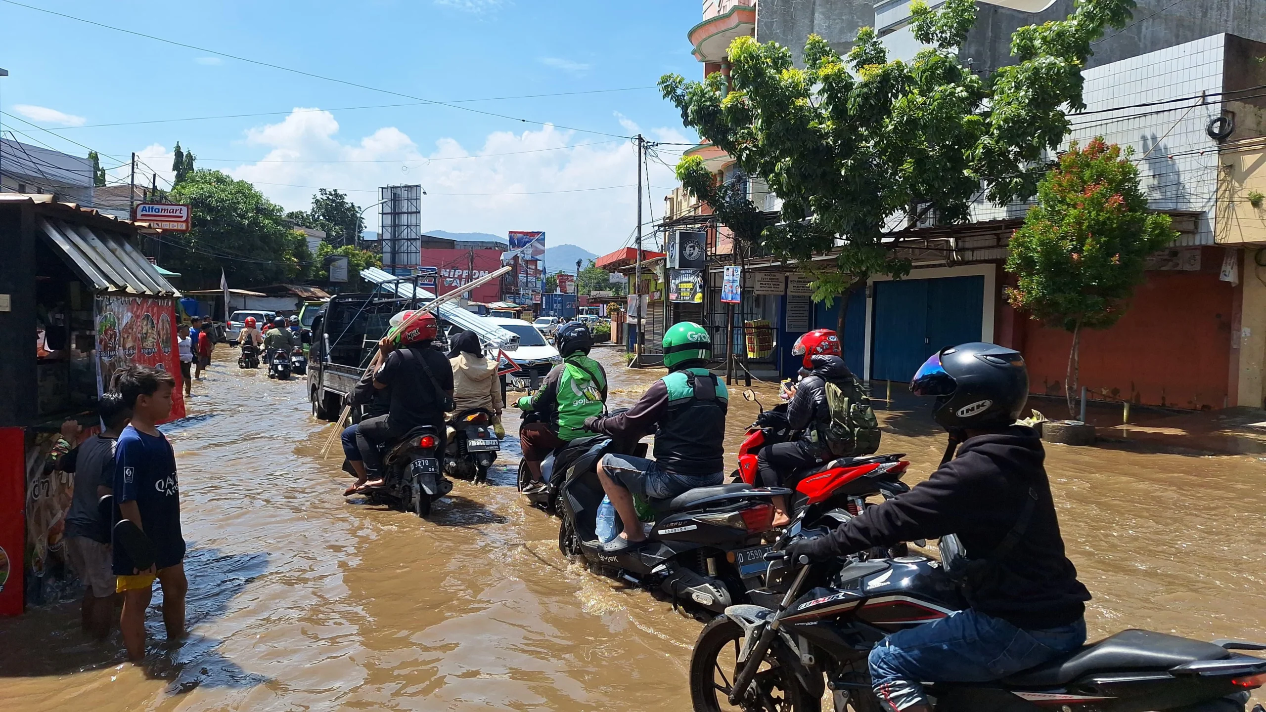 Masyarakat saat melintas Jalan Raya Dayeuhkolot yang tergenang banjir pada Kamis (21/11). Foto Agi