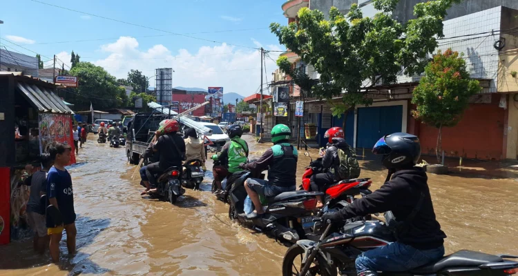 Warga saat melintas Jalan Raya Dayeuhkolot yang tergenang banjir, Kamis (21/11). Foto Agi