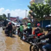 Sejumlah pengendara motor terhambat saat melintas Jalan Raya Dayeuhkolot akibat tergenang banjir. (Agi/Jabar Ekspres)