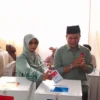 Calon Bupati Bandung Nomor Urut 2, Dadang Supriatna (kanan) bersama sang istri, Emma Dety (kiri) terlihat kompak mengenakan pakaian berwarna hijau, saat di lokasi TPS wilayah Desa Tegalluar, Kecamatan Bojongsoang, Kabupaten Bandung. (Jabar Ekspres)