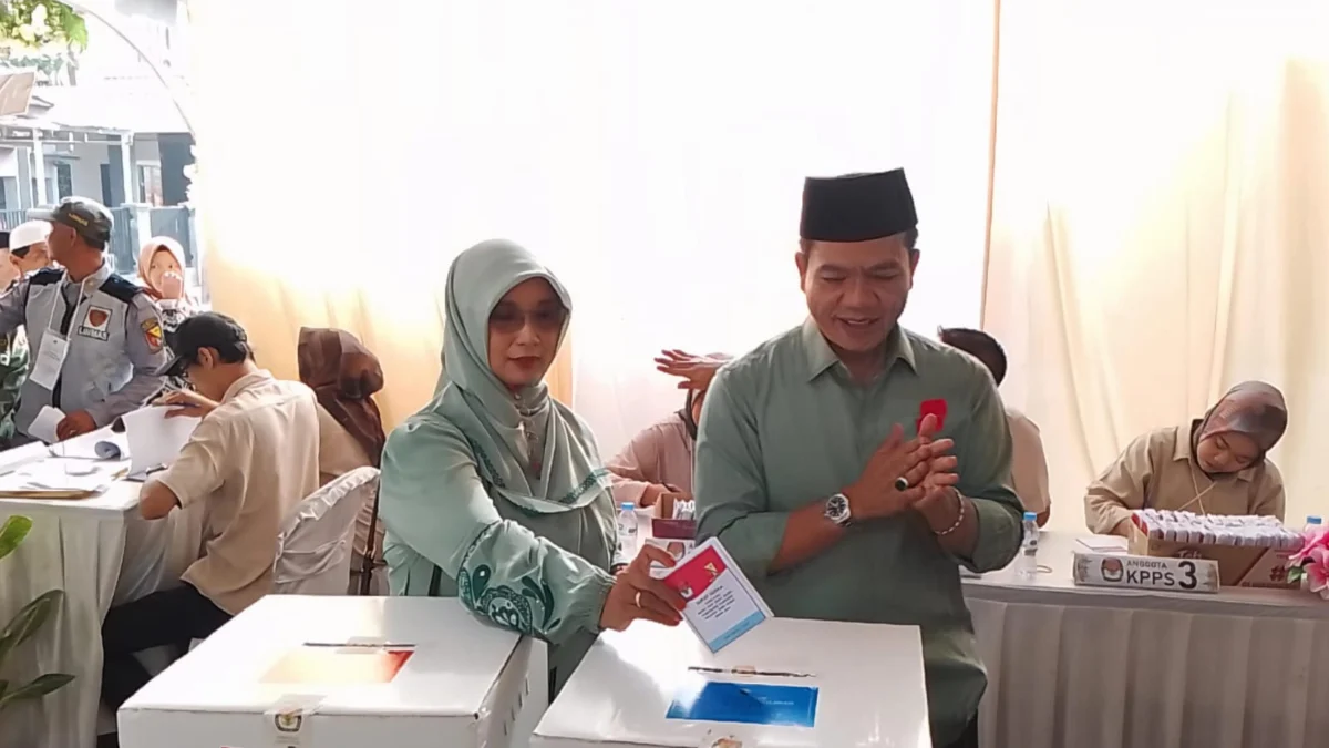 Calon Bupati Bandung Nomor Urut 2, Dadang Supriatna (kanan) bersama sang istri, Emma Dety (kiri) terlihat kompak mengenakan pakaian berwarna hijau, saat di lokasi TPS wilayah Desa Tegalluar, Kecamatan Bojongsoang, Kabupaten Bandung. (Jabar Ekspres)