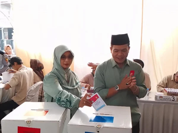 Calon Bupati Bandung Nomor Urut 2, Dadang Supriatna (kanan) bersama sang istri, Emma Dety (kiri) terlihat kompak mengenakan pakaian berwarna hijau, saat di lokasi TPS wilayah Desa Tegalluar, Kecamatan Bojongsoang, Kabupaten Bandung. (Jabar Ekspres)