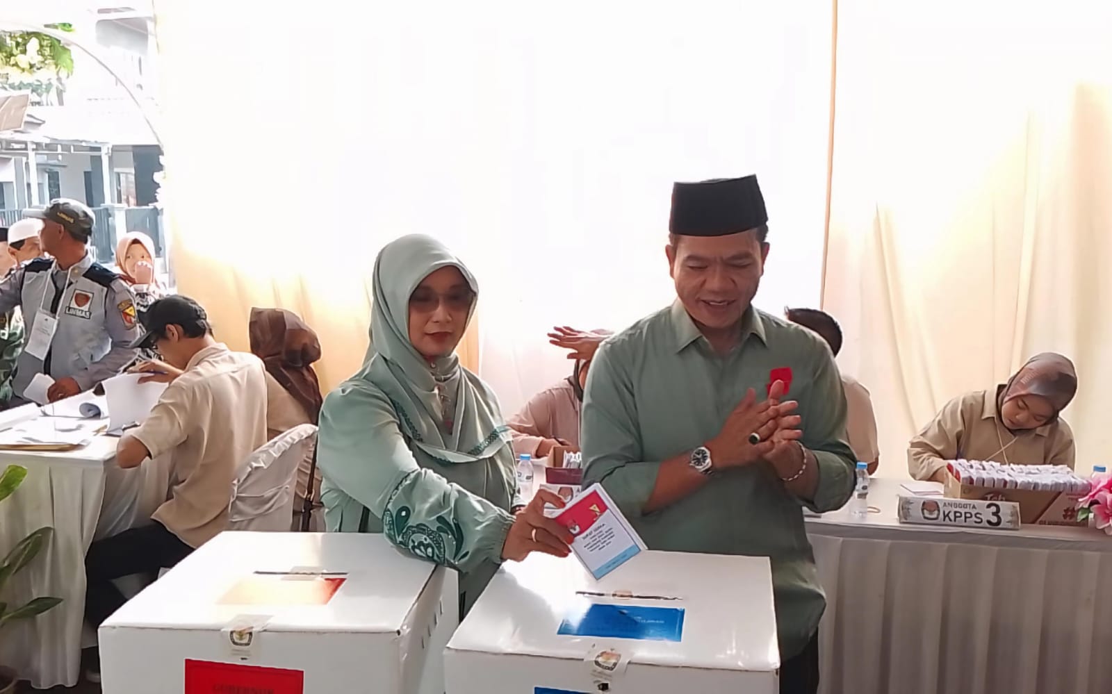 Calon Bupati Bandung Nomor Urut 2, Dadang Supriatna (kanan) bersama sang istri, Emma Dety (kiri) terlihat kompak mengenakan pakaian berwarna hijau, saat di lokasi TPS wilayah Desa Tegalluar, Kecamatan Bojongsoang, Kabupaten Bandung. (Jabar Ekspres)