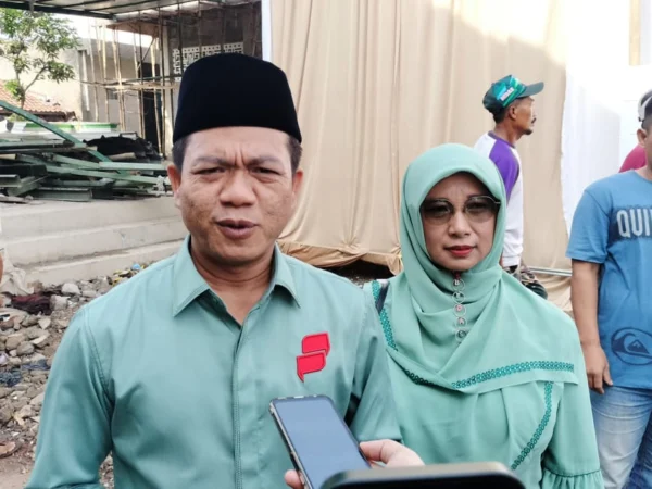 Calon Bupati Bandung Nomor Urut 2, Dadang Supriatna (kanan) bersama sang istri, Emma Dety (kiri) terlihat kompak mengenakan pakaian berwarna hijau, saat di lokasi TPS wilayah Desa Tegalluar, Kecamatan Bojongsoang, Kabupaten Bandung. (Jabar Ekspres)