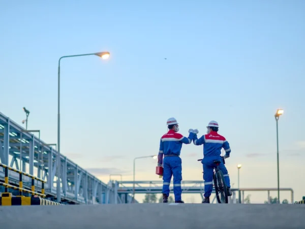 Dua Perwira PT Pertamina Hulu Rokan (PHR) tengah melakukan peninjauan di salah satu lapangan minyak.