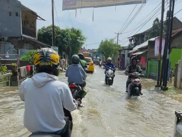 Para pengendara motor yang melintasi banjir di wilayah Sapan, Desa Tegalluar, Kecamatan Bojongsoang, Kabupaten Bandung beberapa waktu lalu. Foto Agi