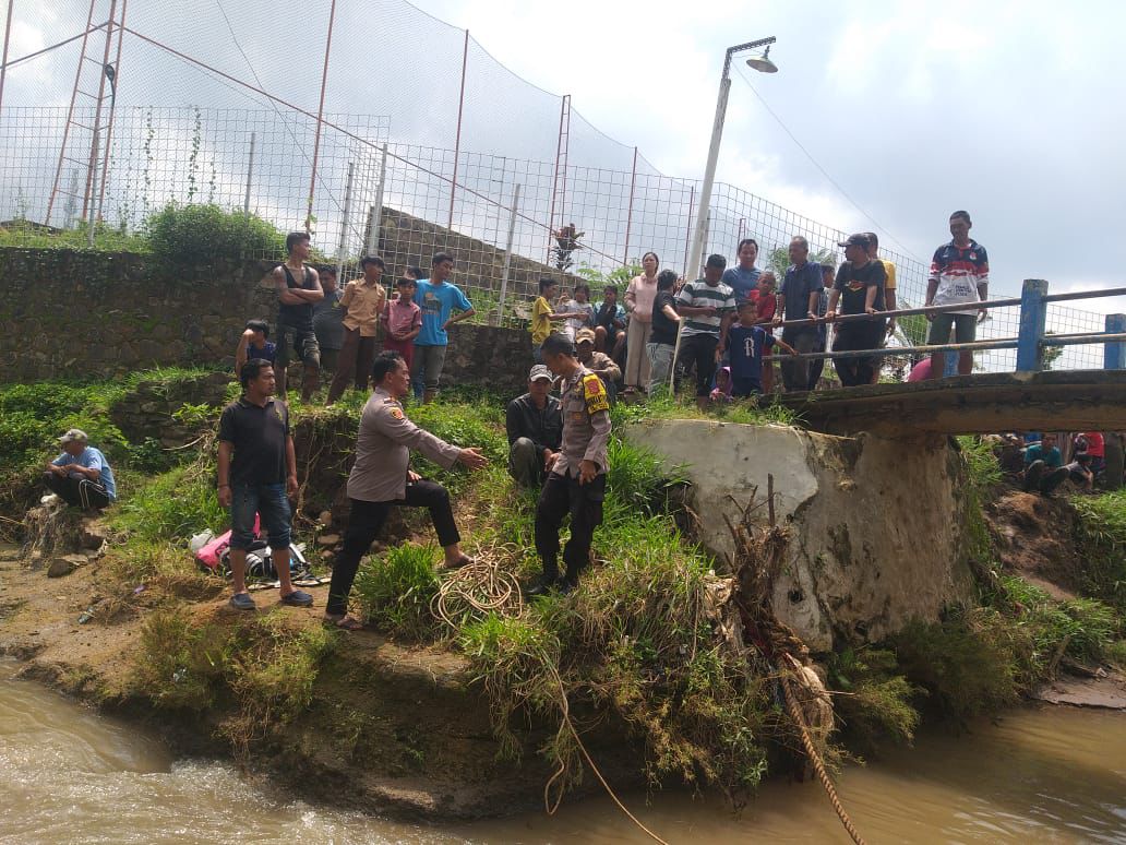 Petugas Polsek Paseh bersama warga saat mengevakuasi korban tenggelam di Sungai Cisunggalah, Desa Cipaku, Kecamatan Paseh, Kabupaten Bandung pada Sabtu (8/12). Foto Istimewa