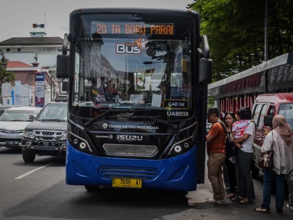 Sejumlah penumpang berjalan menaiki bus Damri di Halte Alun-Alun Bandung, Kota Bandung, Jum'at (27/12). Foto: Dimas Rachmatsyah/Jabar Ekspres