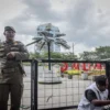 Petugas Satpol PP berjaga di sekitar Taman Alun-Alun Bandung, Kota Bandung, Jum'at (27/12). Pemerintah Kota (Pemkot) Bandung melakukan revitalisasi Alun-Alun Bandung dengan mengganti rumput sintetis yang ditargetkan rampung November, hingga saat ini belum diresmikan. Foto: Dimas Rachmatsyah / Jabar Ekspres