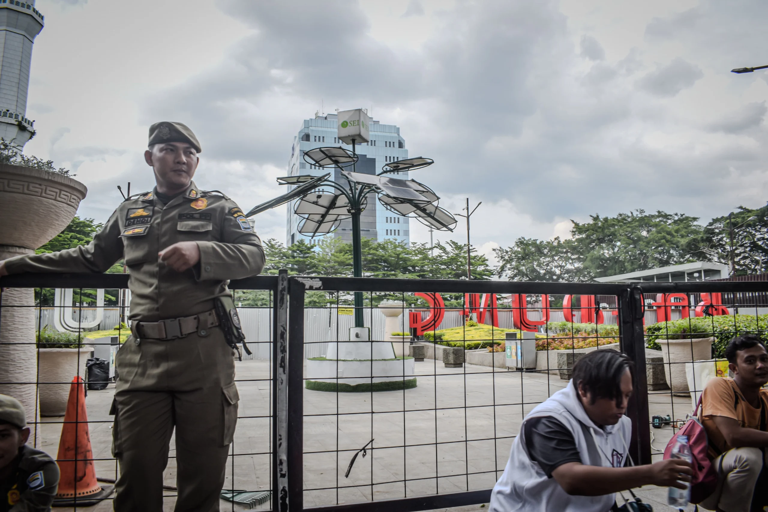 Petugas Satpol PP berjaga di sekitar Taman Alun-Alun Bandung, Kota Bandung, Jum'at (27/12). Pemerintah Kota (Pemkot) Bandung melakukan revitalisasi Alun-Alun Bandung dengan mengganti rumput sintetis yang ditargetkan rampung November, hingga saat ini belum diresmikan. Foto: Dimas Rachmatsyah / Jabar Ekspres