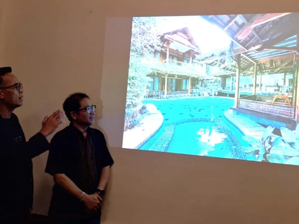 Sales Manager Ryandra Syasa Elvietra dan Executive Assistant Manager Kampung Sumber Alam Resort Gada Putra saat menunjukkan salah satu venue penginapan Kampung Sumber Alam Resort yang berada di atas kolam.