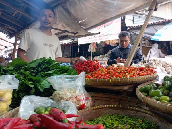 Seorang pedagang sayuran di Pasar Induk Gedebage, Kota Bandung saat melayani pelanggan, beberapa waktu lalu. (Nizar/Jabar Ekspres)