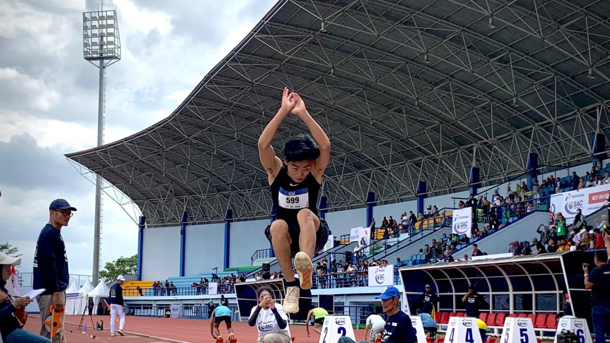 Muhammad Isra Tizani curi perhatian di cabang olahraga atletik lompat jauh, di kejuaraan Pertamina SAC Indonesia West Java Qualifiers, Jumat (13/12). (Sadam Husen / JE)