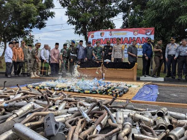 Kapolres Banjar bersama Forkopimda memusnahkan ratusa botol minuman keras dan knalpot brong di halaman Mapolres Banjar, Selasa 31 Desember 2024. (Cecep Herdi/Jabar Ekspres)