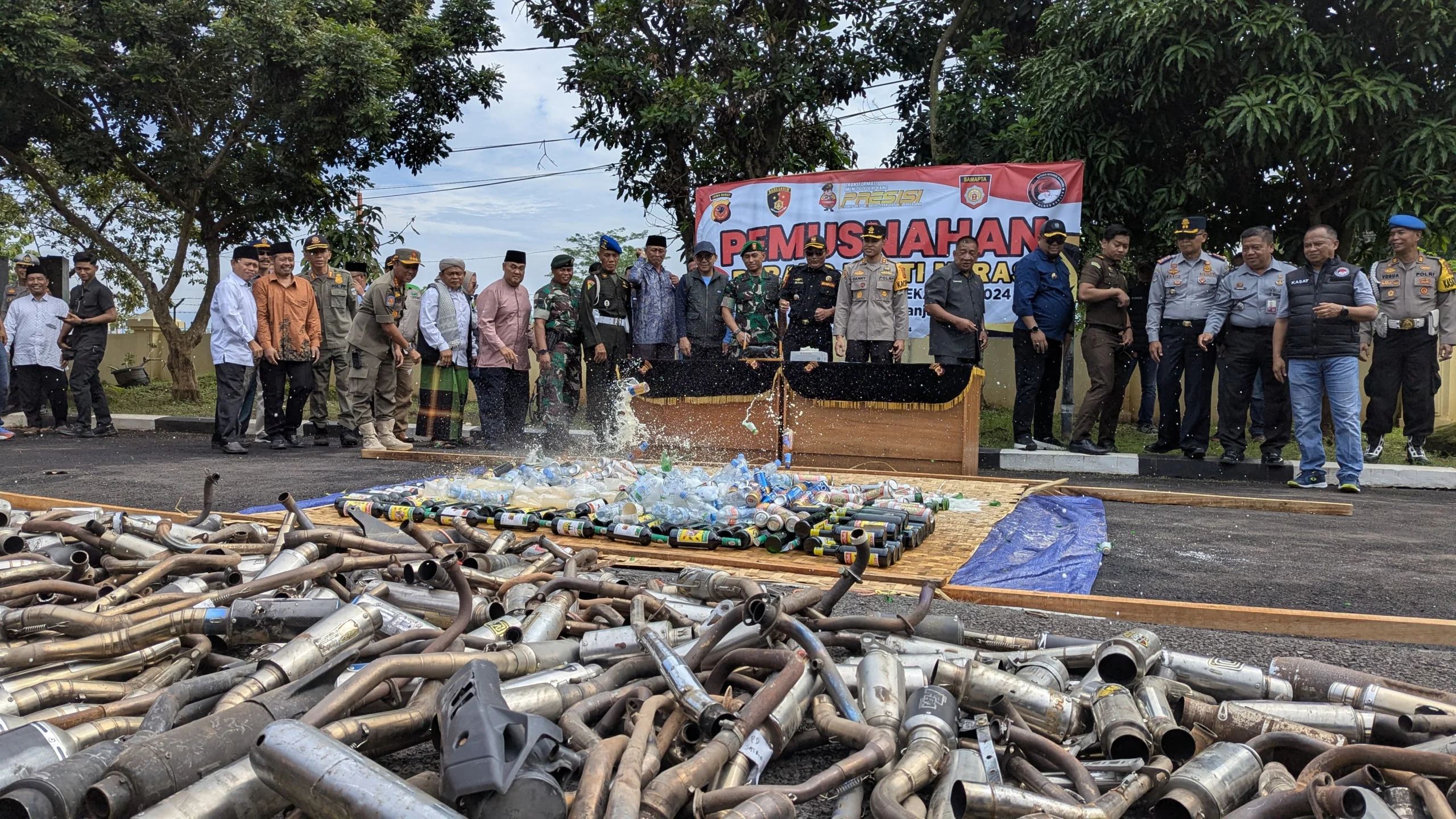 Kapolres Banjar bersama Forkopimda memusnahkan ratusa botol minuman keras dan knalpot brong di halaman Mapolres Banjar, Selasa 31 Desember 2024. (Cecep Herdi/Jabar Ekspres)