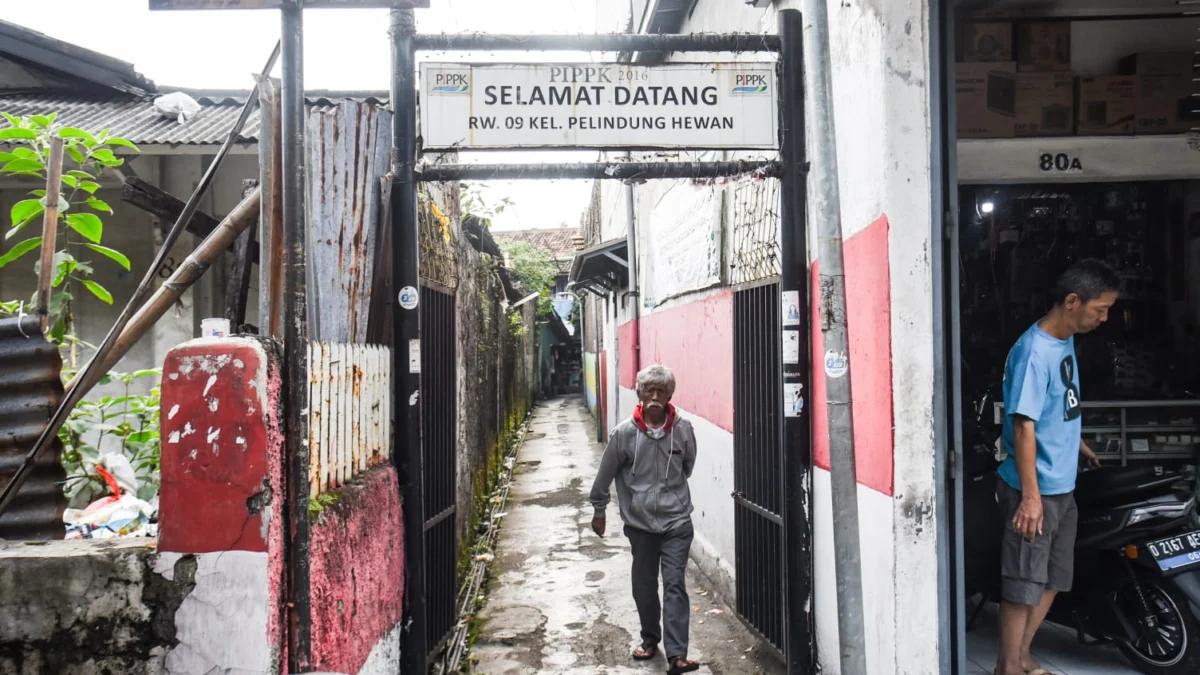 Seorang warga berjalan di Gang Karyamas l, Jl. Moh Toha, Kota Bandung, pada (31/1) sore. Foto: Dimas Rachmatsyah / Jabar Ekspres