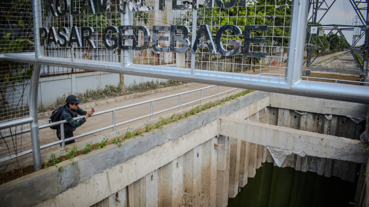 Warga melihat kondisi terkini kolam retensi Gedebage, Kota Bandung, Jum'at (3/1). Foto: Dimas Rachmatsyah/ Jabar Ekspres