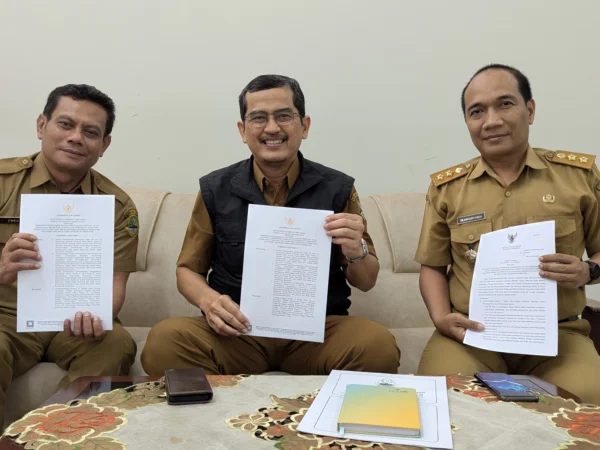 Kepala Pusat Pengelolaan Pendapatan Daerah Wilayah (P3DW) Kota Banjar, Benny Suranata (tengah) menunjukkan Kepgub Jabar tentang relaksasi pajak kendaraan bermotor, Senin 6 Januari 2025. (Cecep Herdi/Jabar Ekspres)