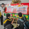 Sejumlah mahasiswa Universitas Bandung menempelkan poster tuntutan kepada pihak kampus di sebuah karangan bunga di Kampus Utama Universitas Bandung, Jalan Muararajeun, Kota Bandung, Senin (6/1). Foto: Dimas Rachmatsyah / Jabar Ekspres