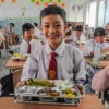 Siswa Sekolah Dasar (SD) menyantap makanan bergizi gratis di SD Angkasa 1 Lanud Husein Sastranegara,Kota Bandung, Senin (6/1). Sekolah-sekolah di Kota Bandung mulai mendapat makanan dari program Makan Bergizi Gratis (MBG) yang mulai perdana digelar pada hari ini. Foto: Dimas Rachmatsyah / Jabar Ekspres