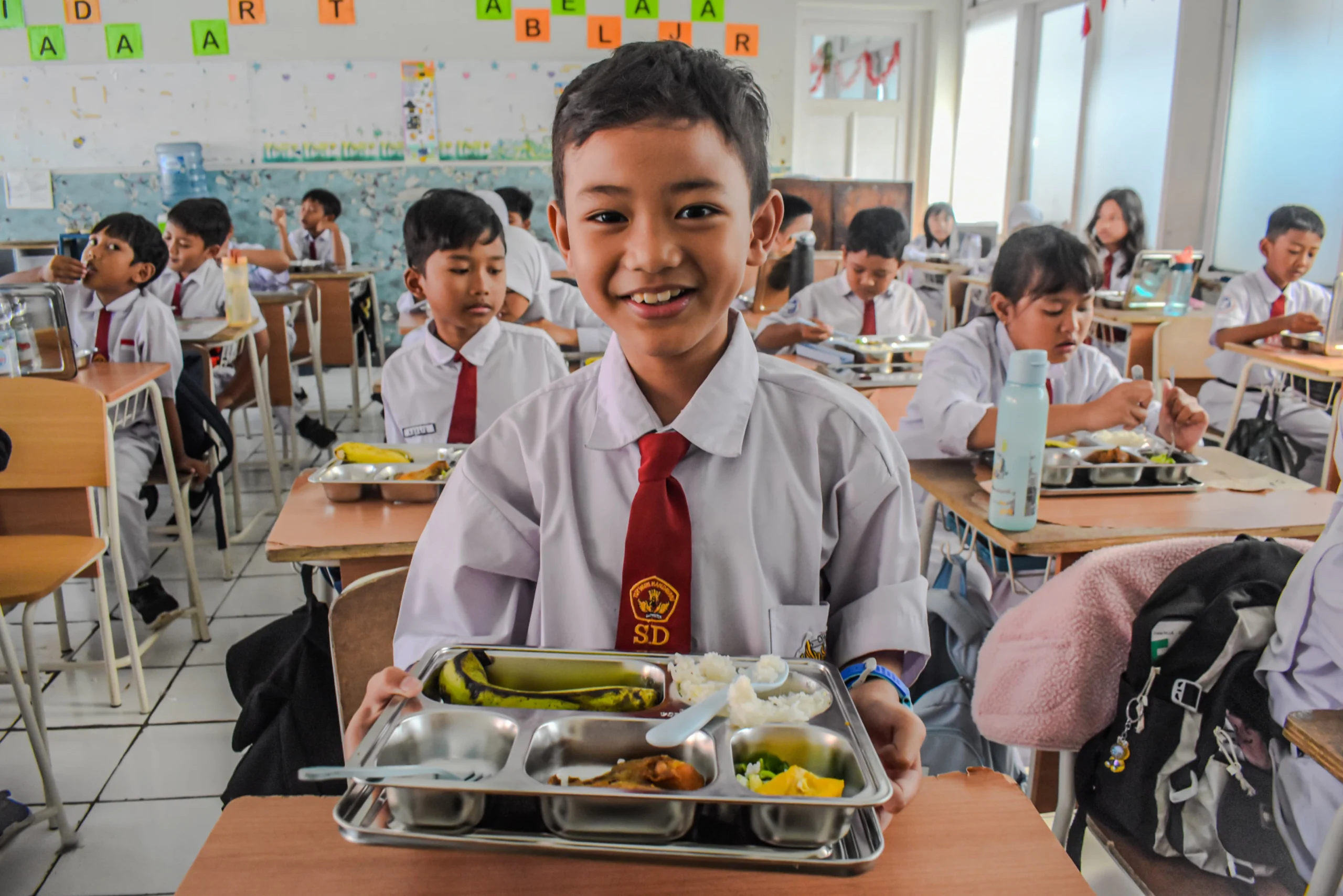 Siswa Sekolah Dasar (SD) menyantap makanan bergizi gratis di SD Angkasa 1 Lanud Husein Sastranegara,Kota Bandung, Senin (6/1). Sekolah-sekolah di Kota Bandung mulai mendapat makanan dari program Makan Bergizi Gratis (MBG) yang mulai perdana digelar pada hari ini. Foto: Dimas Rachmatsyah / Jabar Ekspres