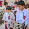 Sejumlah siswa Sekolah Dasar (SD) membawa sisa tempat makanan bergizi gratis di SD Negeri 193 Caringin,Kota Bandung, Senin (6/1). Sekolah-sekolah di Kota Bandung mulai mendapat makanan dari program Makan Bergizi Gratis (MBG) yang mulai perdana digelar pada hari ini. Foto: Dimas Rachmatsyah / Jabar Ekspres