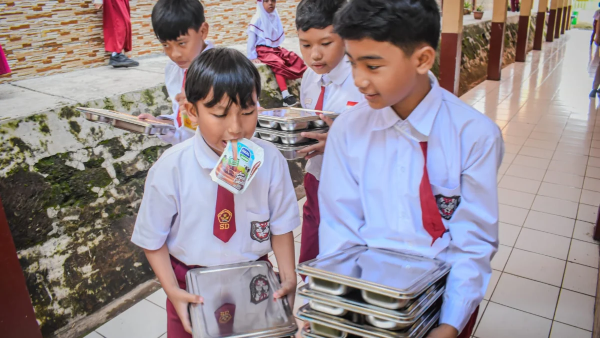 Sejumlah siswa Sekolah Dasar (SD) membawa sisa tempat makanan bergizi gratis di SD Negeri 193 Caringin,Kota Bandung, Senin (6/1). Sekolah-sekolah di Kota Bandung mulai mendapat makanan dari program Makan Bergizi Gratis (MBG) yang mulai perdana digelar pada hari ini. Foto: Dimas Rachmatsyah / Jabar Ekspres