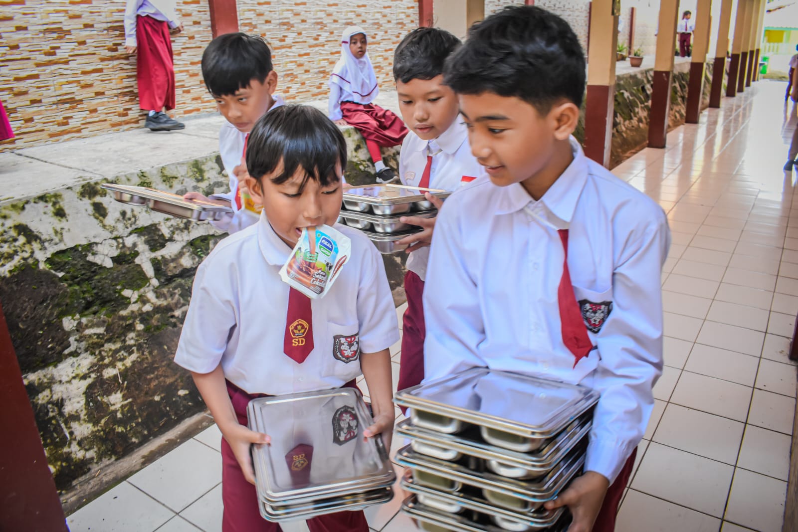 Sejumlah siswa Sekolah Dasar (SD) membawa sisa tempat makanan bergizi gratis di SD Negeri 193 Caringin,Kota Bandung, Senin (6/1). Sekolah-sekolah di Kota Bandung mulai mendapat makanan dari program Makan Bergizi Gratis (MBG) yang mulai perdana digelar pada hari ini. Foto: Dimas Rachmatsyah / Jabar Ekspres