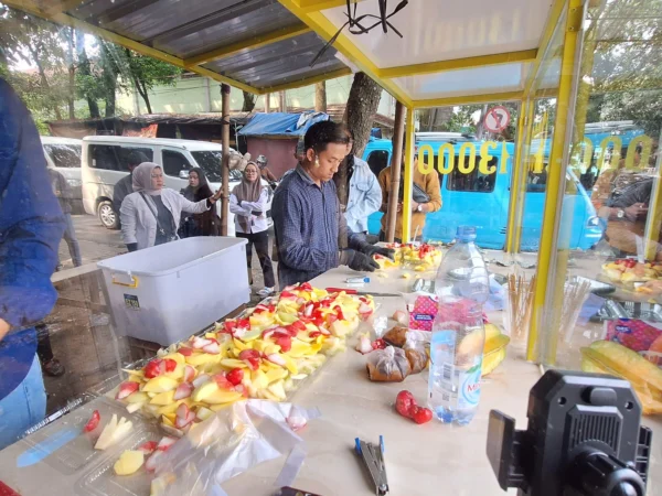 Penjual rujak, Tedi Supriadi (27) saat menjajakan dagangannya di Jalan Pesantren, Alun-alun Soreang, Kabupaten Bandung, Selasa (7/1/2025). Foto Agi