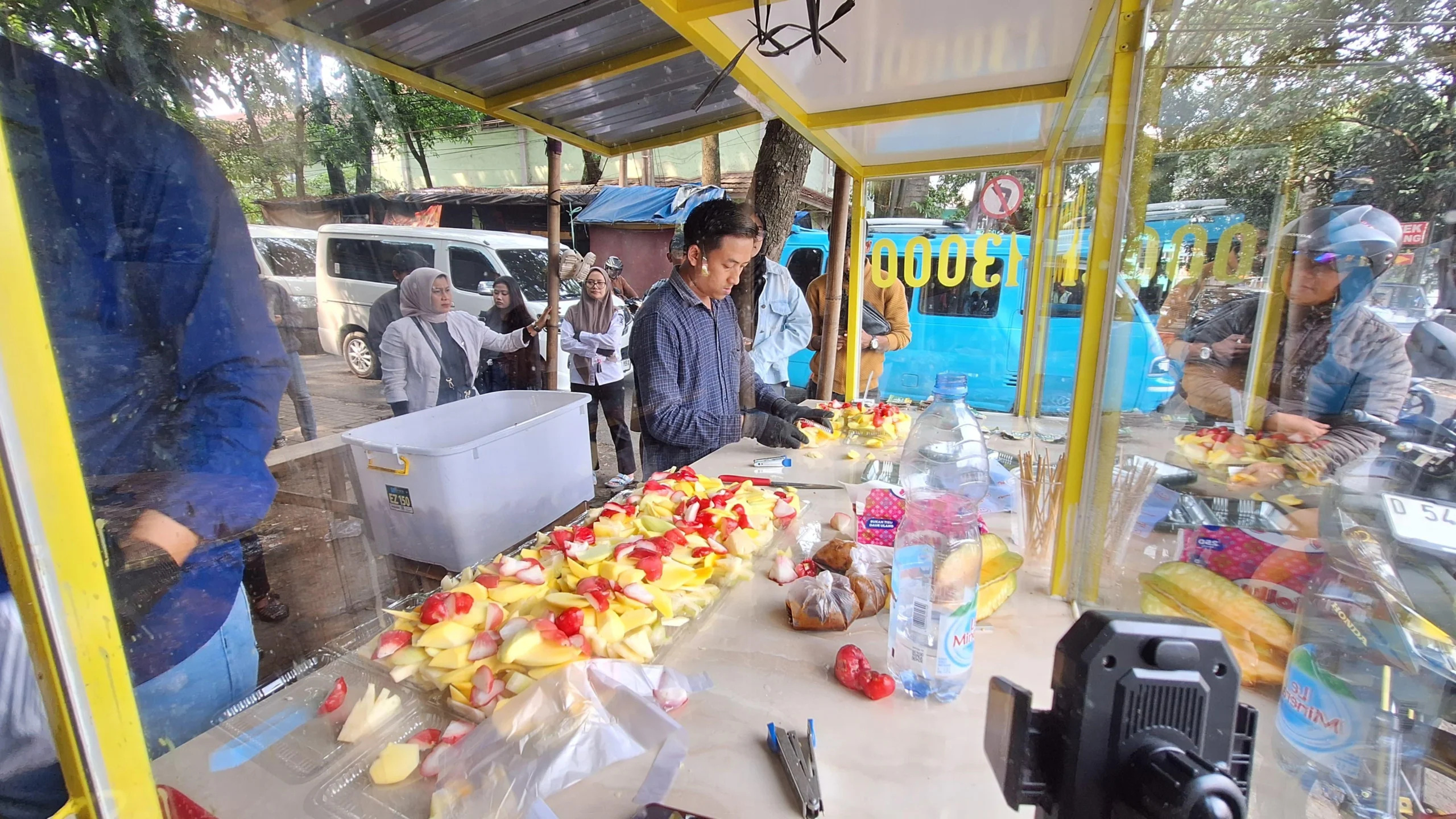 Penjual rujak, Tedi Supriadi (27) saat menjajakan dagangannya di Jalan Pesantren, Alun-alun Soreang, Kabupaten Bandung, Selasa (7/1/2025). Foto Agi