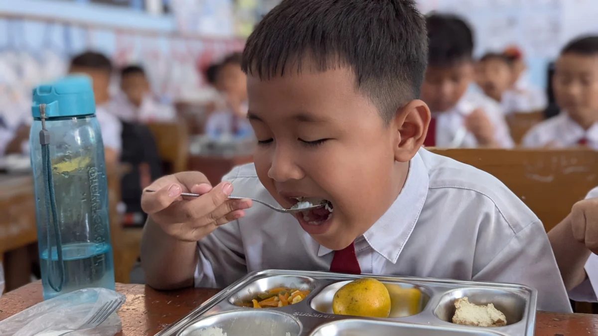 Salah satu siswa SD Negeri 1 Banjarsari Kabupaten Ciamis menyantap menu makan bergizi gratis (MBG) yang mulai dibagikan pada Senin 13 Januari 2025. (Cecep Herdi/Jabar Ekspres)