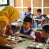 Siswa Sekolah Dasar (SD) menyantap makanan bergizi gratis di SD Negeri 272 Sukasari,Kota Bandung, Senin (13/1). Foto: Dimas Rachmatsyah / Jabar Ekspres