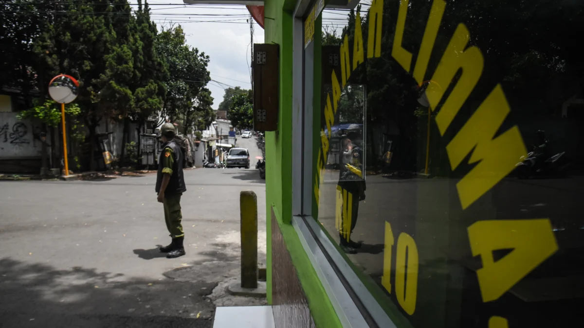 Ilustrasi: Petugas linmas berjaga di depan komplek perumahan di jalan Baladewa, Kota Bandung, Rabu (15/1). Foto: Dimas Rachmatsyah / Jabar Ekspres