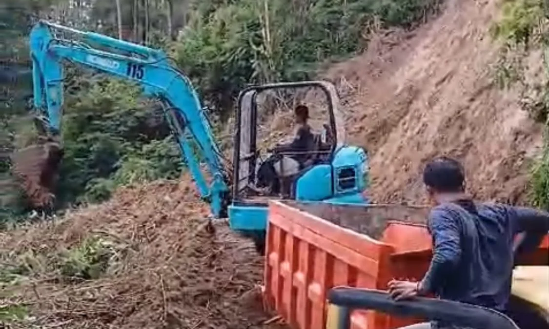 Alat berat diterjunkan dalam proses evakuasi meterial longsor yang menutup akses jalan di Kampung Tugu, Kecamatan Gununghalu. Dok BPBD KBB