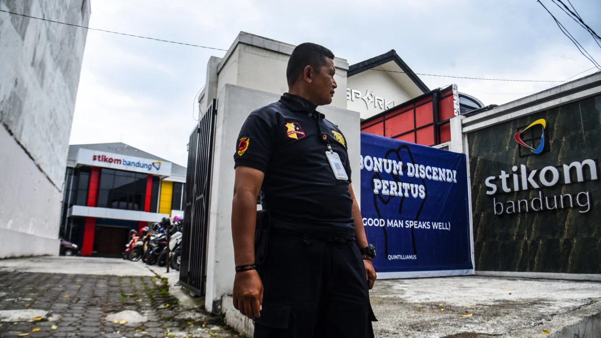 Petugas keamanan berjaga digerbang pintu masuk utama kampus di Stikom Bandung, Sabtu (1/2). Foto: Dimas Rachmatsyah / Jabar Ekspres