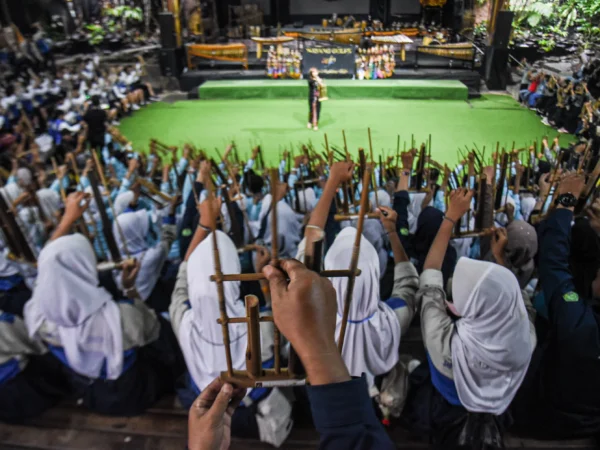 Pengunjung mencoba memainkan alat musik tradisional angklung di Saung Angklung Udjo, Kota Bandung, Senin (24/2). Foto: Dimas Rachmatsyah / Jabar Ekspres