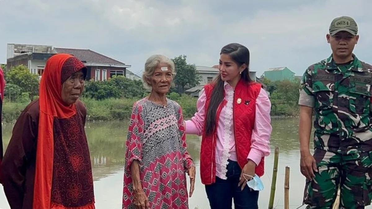 Anggota DPRD Kabupaten Bandung Angie Natesha Goenadi Go menyerahkan bantuan kepada warga terdampak banjir di Desa Sukamenak Kecamatan Margahayu Kabupaten Bandung, Senin (10/3).