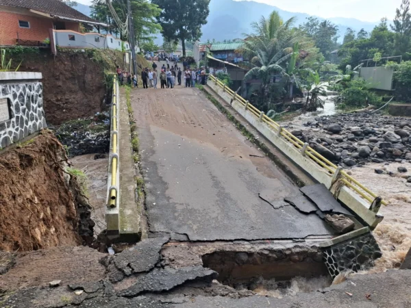 Kondisi jembatan penghubung Desa Leuwimalang dan Desa Jogjogan yang amblas akibat luapan Sungai Ciliwung. Foto: Sandika / Jabar Ekspres