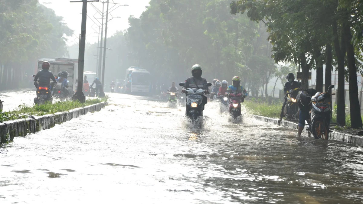 Pengendara motor melintasi banjir di kawasan SOR GBLA, Kota Bandung, Jum'at (7/3). Foto: Dimas Rachmatsyah / Jabar Ekspres