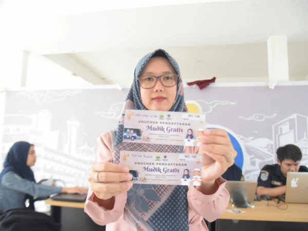 Seorang warga menunjukan voucher mudik gratis di Jembatan Penyeberangan Orang (JPO) Asia Afrika, Kota Bandung, Rabu (12/3). Foto: Dimas Rachmatsyah / Jabar Ekspres