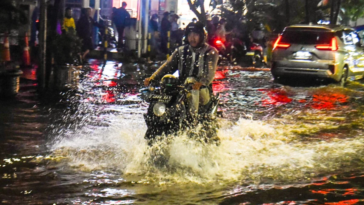 Seorang pengendara motor melintasi jalan yang tergenang banjir di Ciwastra, Kota Bandung, Jumat (7/3). Foto: Dimas Rachmatsyah / Jabar Ekspres