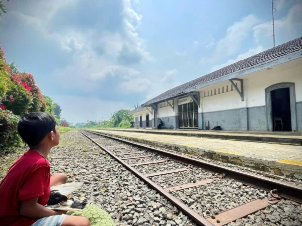 Seorang anak dan warga di sekitar Stasiun Tagog Apu Padalarang, Bandung Barat beraktivitas di jalur kereta api nonaktif. Dok Jabar Ekspres Suwitno