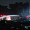 Petugas melakukan pendinginan sisa kebakaran bangunan jongko kayu di kawasan Sukahaji, Babakan Cipayaray, Kota Bandung, Kamis (10/4). Foto: Dimas Rachmatsyah / Jabar Ekspres