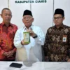 Ketua Baznas Ciamis, Drs H Lili Miftah (tengah) menunjukkan kencleng yang disebar ke masyarakat dalam program penghimpunan infak, Rabu (23/4/2025). (Cecep Herdi/Jabar Ekspres)