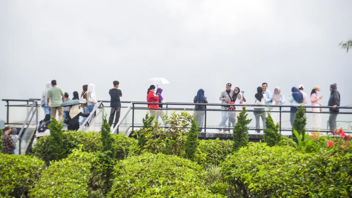 Wisatawan berfoto di wahana kebun teh Nimo Skybridge di objek wisata Nimo Highland, Pangalengan, Kabupaten Bandung, Jum'at (4/4). Foto: Dimas Rachmatsyah / Jabar Ekspres